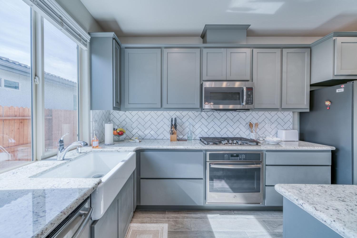 1009 Skylar Lane Clovis, CA 93619 - Photo 7 of 32 a kitchen with granite countertop a sink stove and cabinets