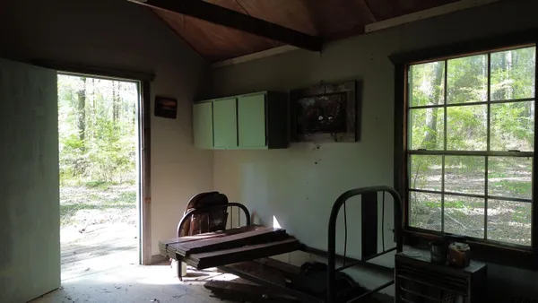 an aerial view of residential house with outdoor space and trees all around