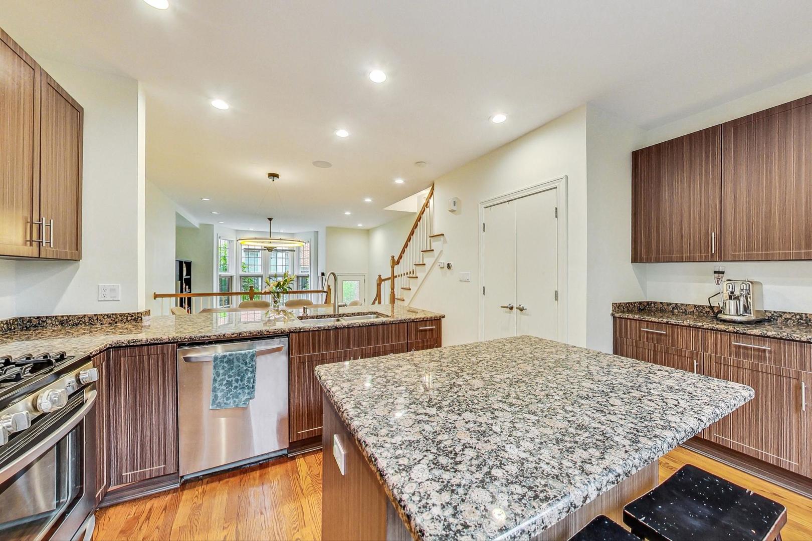 18 North Ada Street, Unit D Chicago, IL 60607 - Photo 19 of 42 a large kitchen with kitchen island granite countertop wooden cabinets a stove and a sink
