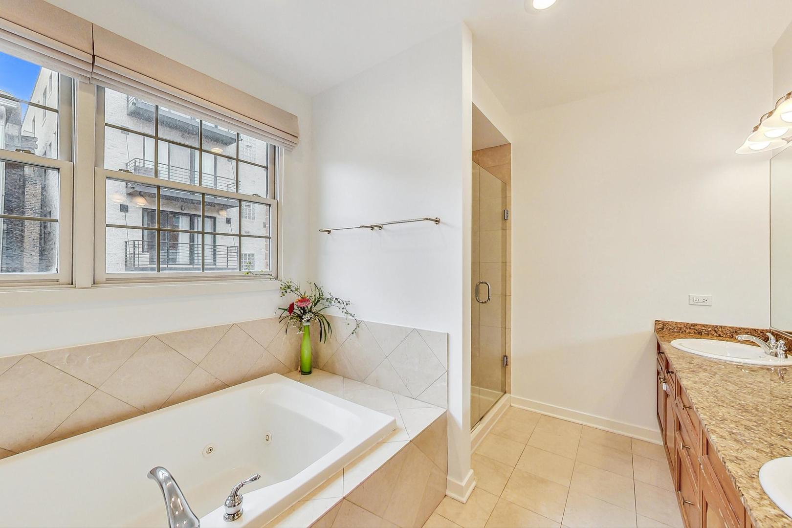 18 North Ada Street, Unit D Chicago, IL 60607 - Photo 25 of 42 a bathroom with a tub and a window