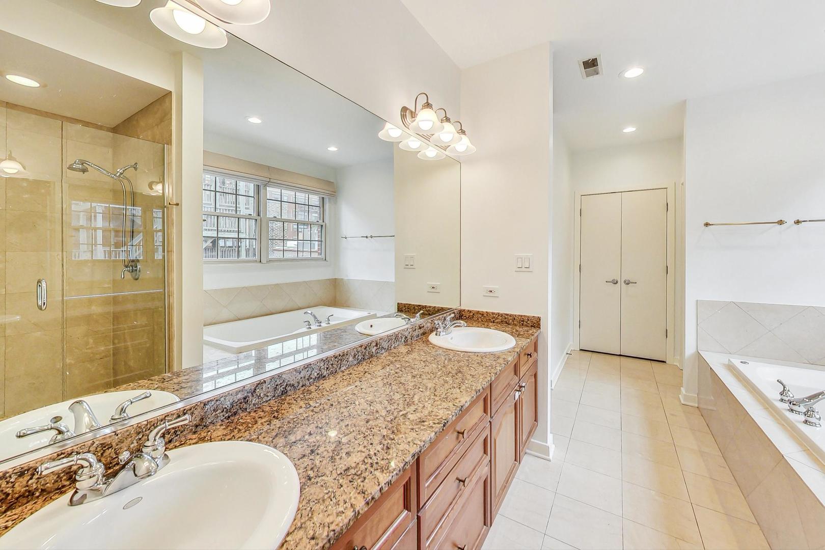 18 North Ada Street, Unit D Chicago, IL 60607 - Photo 26 of 42 a bathroom with a granite countertop sink a large mirror and a bathtub