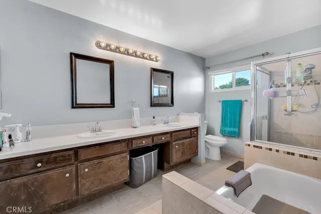 a spacious bathroom with a double vanity sink mirror and bathtub