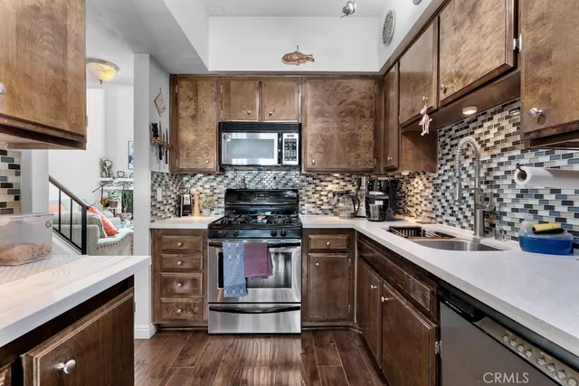 a kitchen with stainless steel appliances a stove and a wooden cabinets