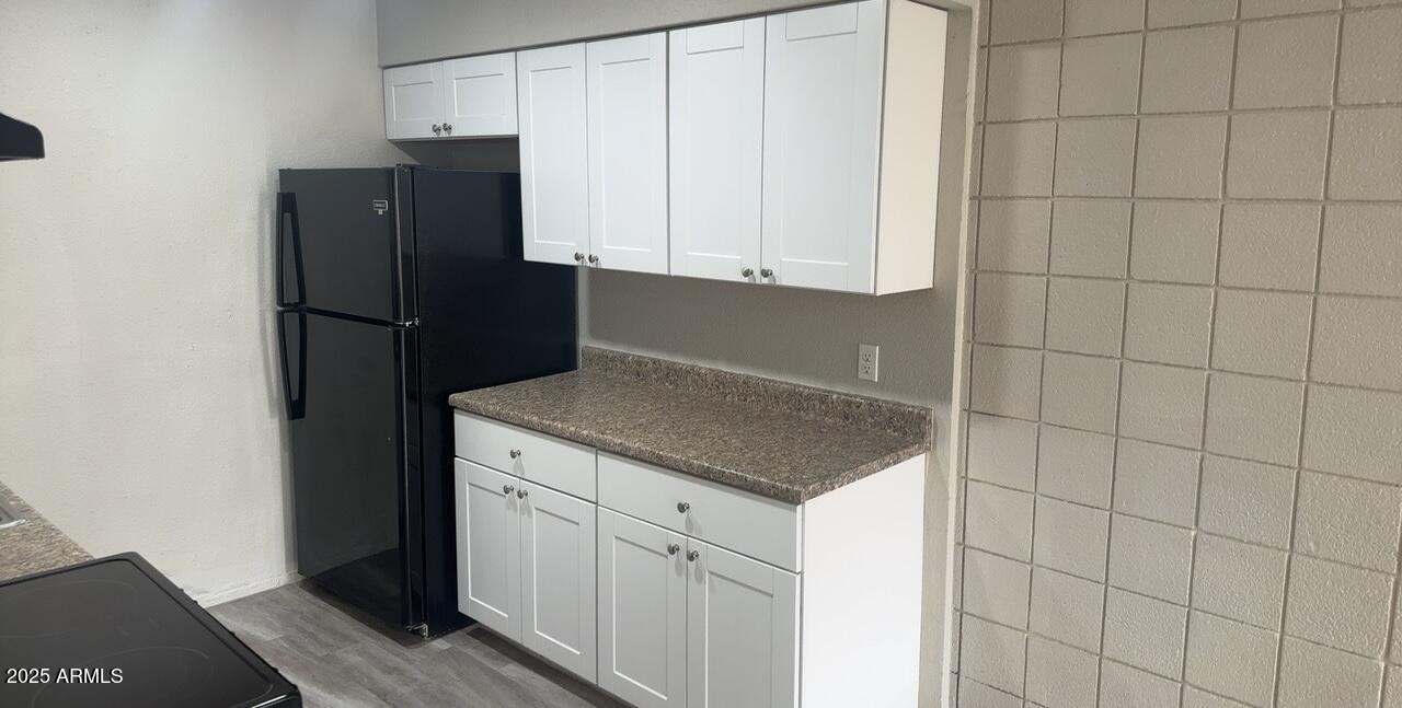 2034 West Cactus Road, Unit C Phoenix, AZ 85029 - Photo 3 of 10 a kitchen with a refrigerator and cabinets