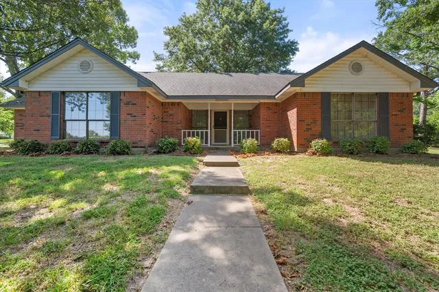 a front view of a house with a yard and porch
