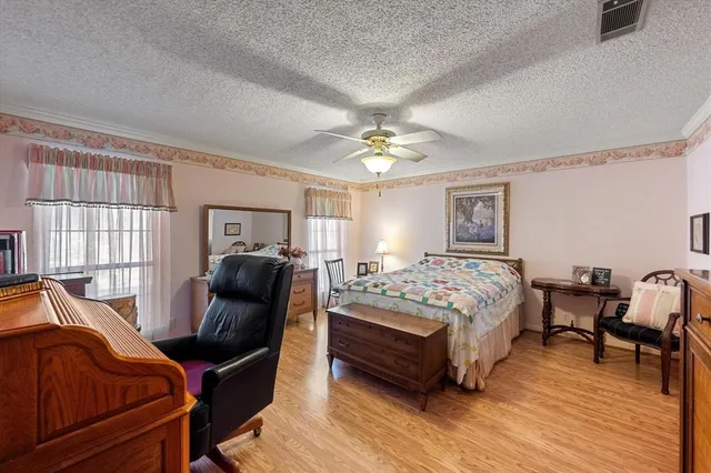 a spacious bedroom with a bed and wooden floor
