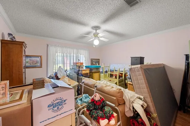 a living room with furniture a flat screen tv and a refrigerator