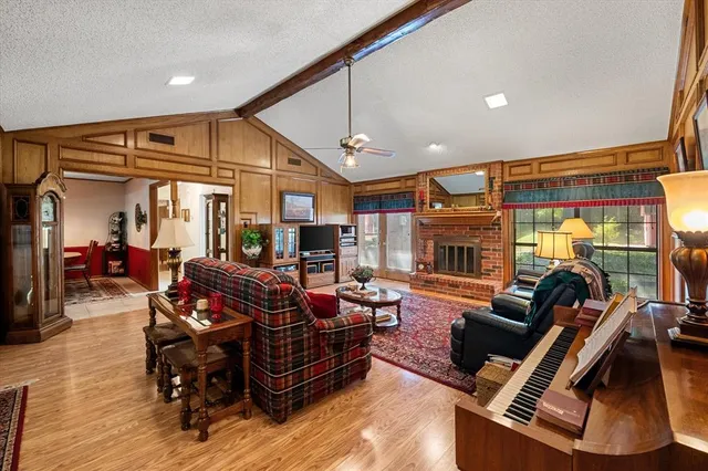 a living room with furniture a flat screen tv and a large window
