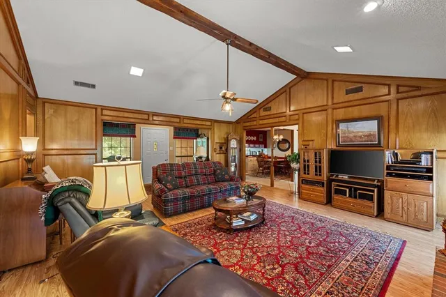 a living room with furniture a flat screen tv and a table