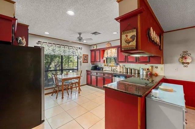 a kitchen with stainless steel appliances granite countertop a stove a refrigerator a kitchen island a dining table and chairs with wooden floor