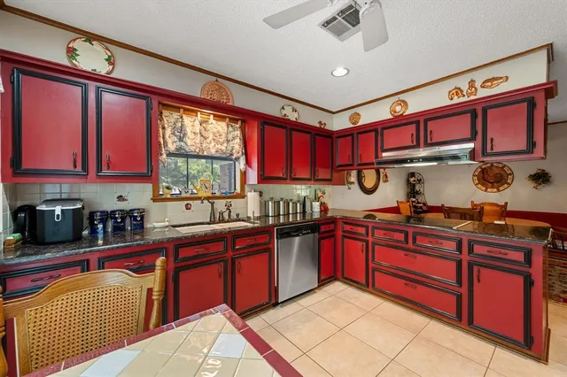 a kitchen with stainless steel appliances granite countertop a sink dishwasher stove and cabinets with wooden floor