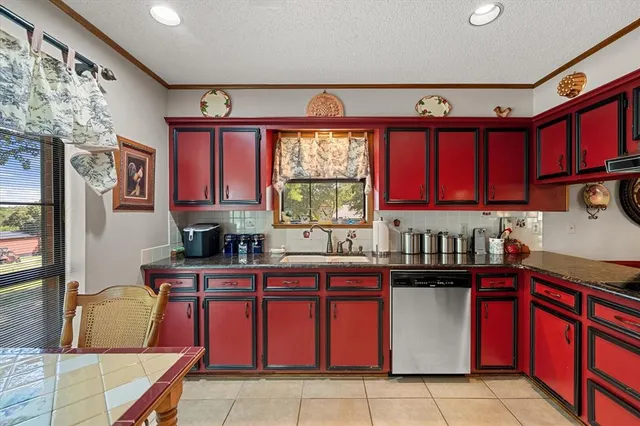 a kitchen with granite countertop a sink window and cabinets