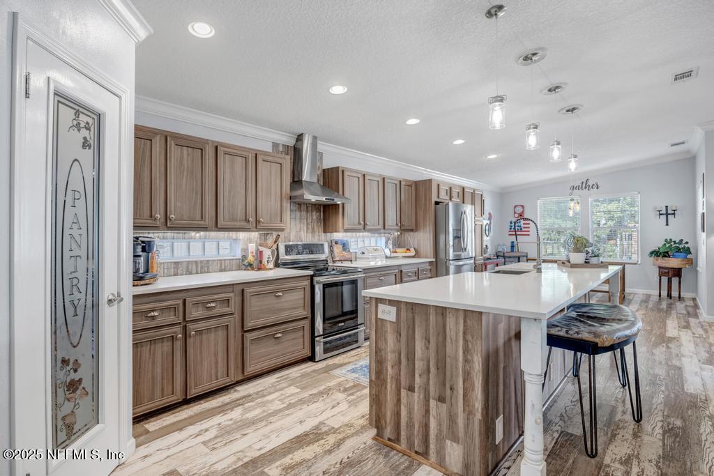 1417 Marlee Road St. Johns, FL 32259 - Photo 16 of 70 a kitchen with kitchen island granite countertop wooden cabinets and white appliances