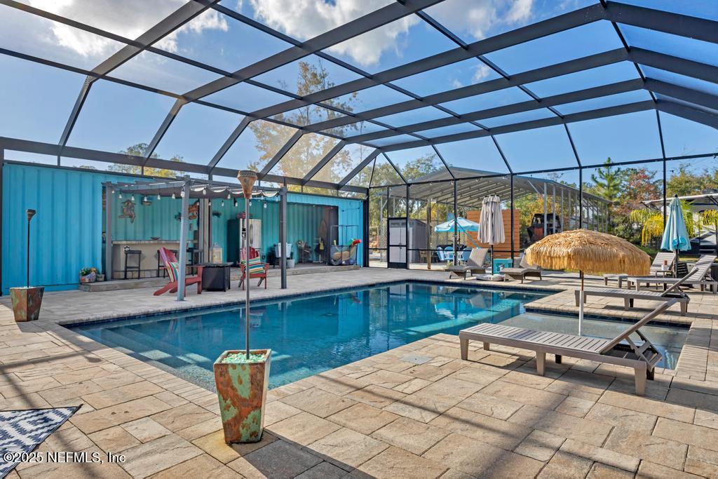 1417 Marlee Road St. Johns, FL 32259 - Photo 40 of 70 a view of a swimming pool with a table and chairs under an umbrella