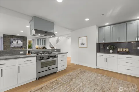 a kitchen with granite countertop white cabinets and stainless steel appliances
