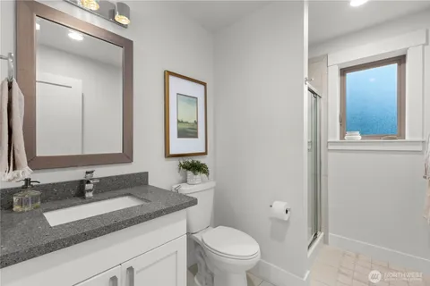 a bathroom with a granite countertop sink toilet and mirror