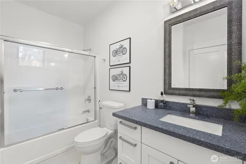 a bathroom with a granite countertop sink toilet and shower