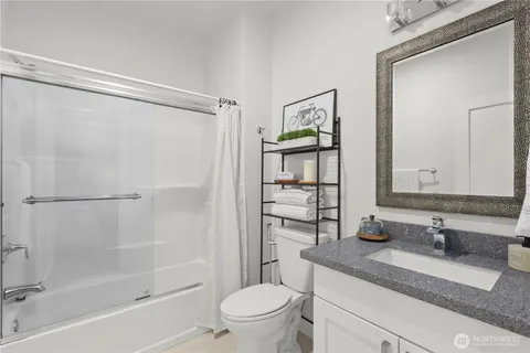a bathroom with a granite countertop sink toilet and shower