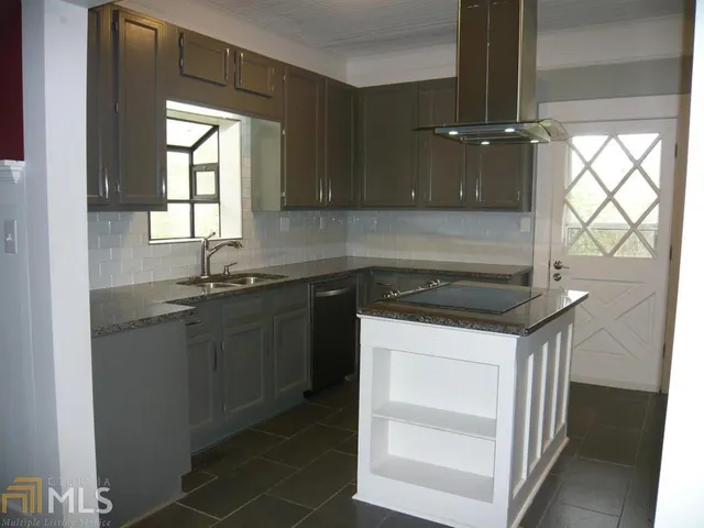 a kitchen with a sink cabinets and a wooden floor