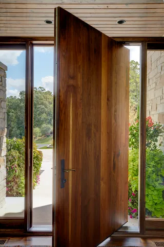 a dining room with furniture potted plants and wooden floor