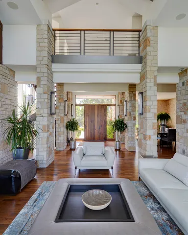 a living room with furniture kitchen view and a large window