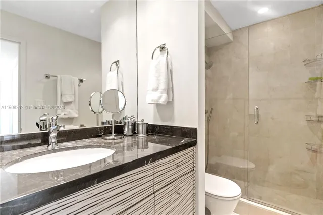 a bathroom with a double vanity sink mirror double shower and toilet