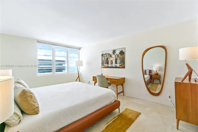 a bedroom with a bed a mirror and a window