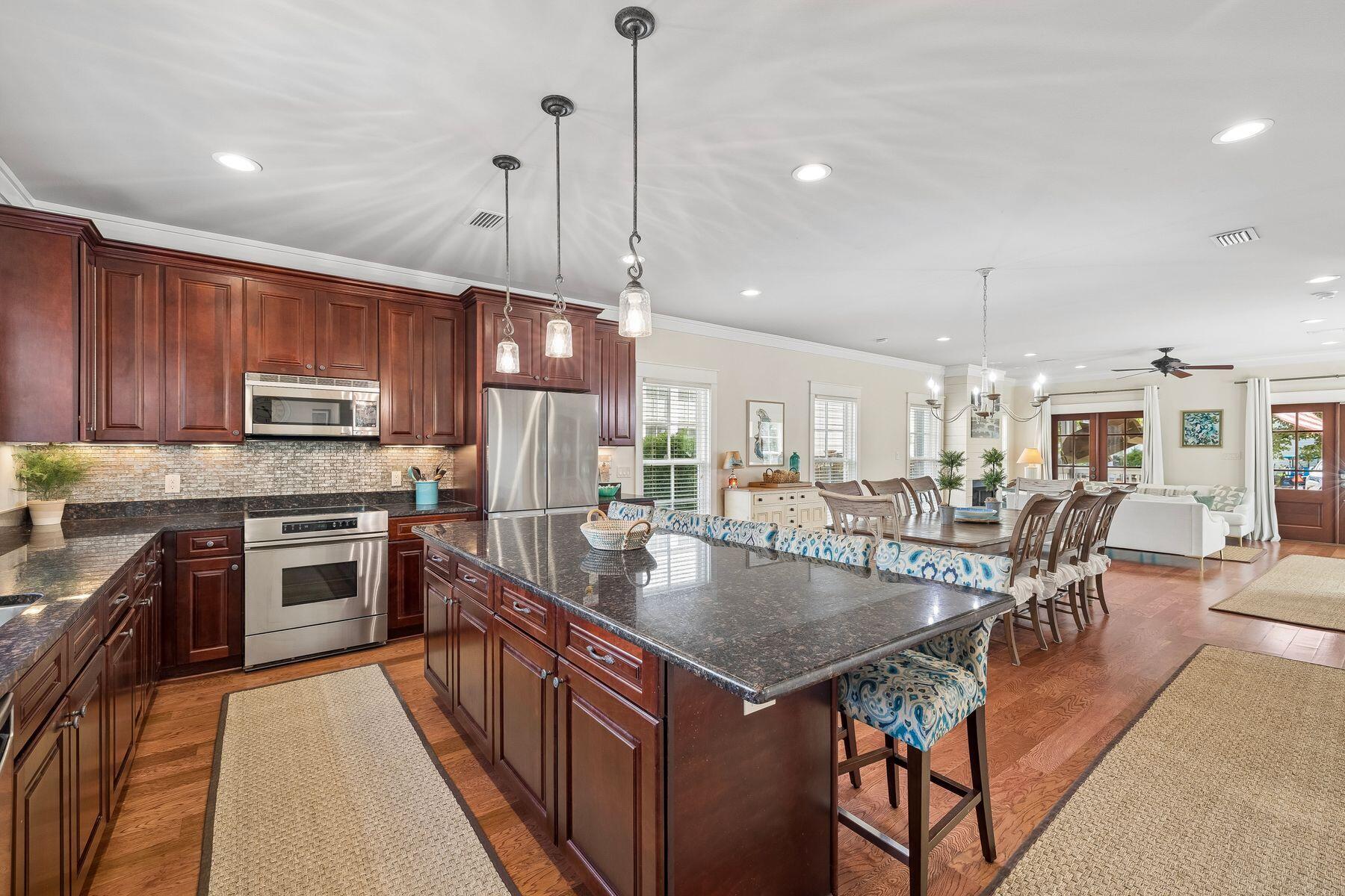 39 Willow Mist Road Inlet Beach, FL 32461 - Photo 11 of 41 a kitchen with stainless steel appliances granite countertop a stove top oven a sink dishwasher a dining table and chairs with wooden floor