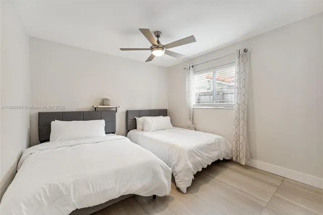 a bedroom with a large bed chandelier and a window
