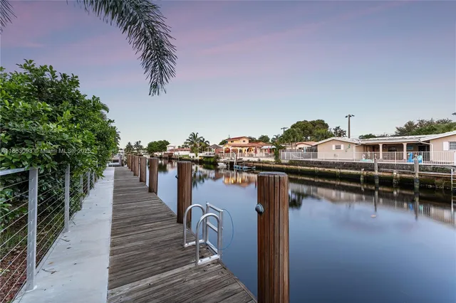 an aerial view of residential houses with outdoor space and lake view