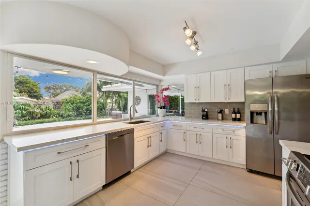a kitchen with white cabinets and white appliances