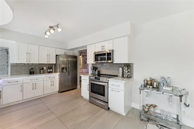 a kitchen with cabinets stainless steel appliances and a counter top space