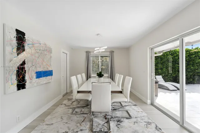 a dining room with furniture and large windows