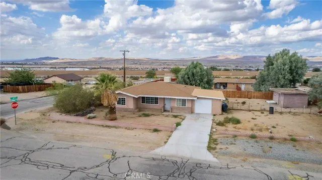 a view of a dry yard with wooden fence