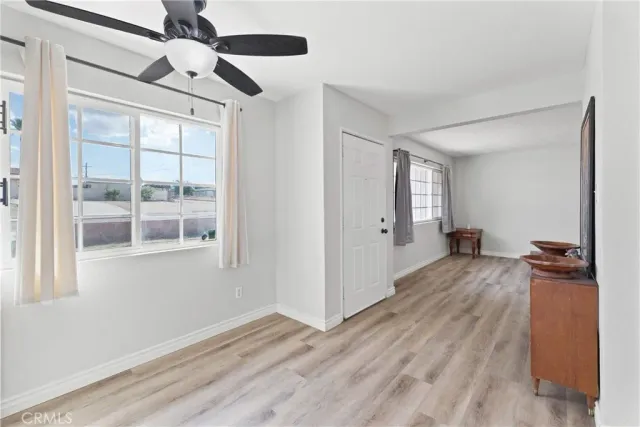 a view of a livingroom with a chandelier fan and wooden floor