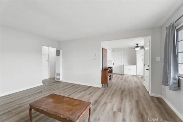 a view of a room with wooden floor and a bathroom