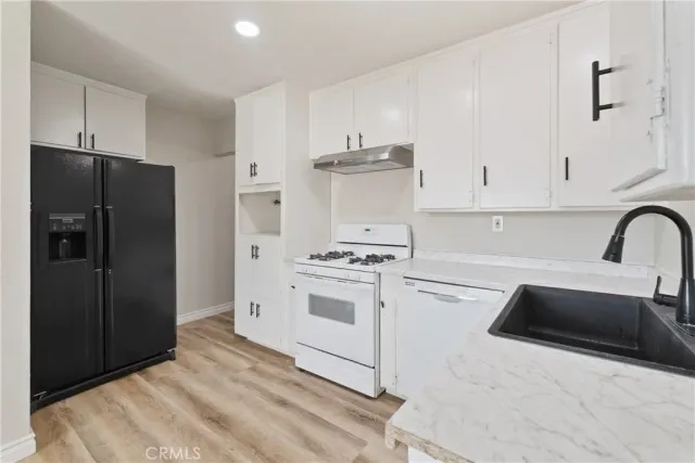 a kitchen with stainless steel appliances a stove a refrigerator and cabinets