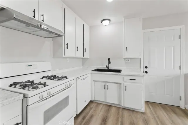 a kitchen with cabinets a sink stove and refrigerator