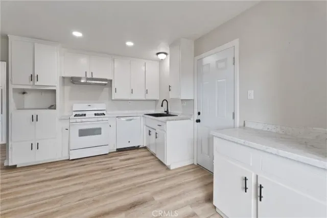 a kitchen with kitchen island white cabinets with white stainless steel appliances