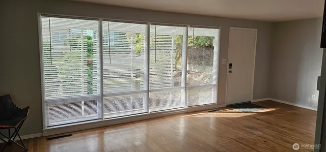 a view of a room with wooden floor and windows
