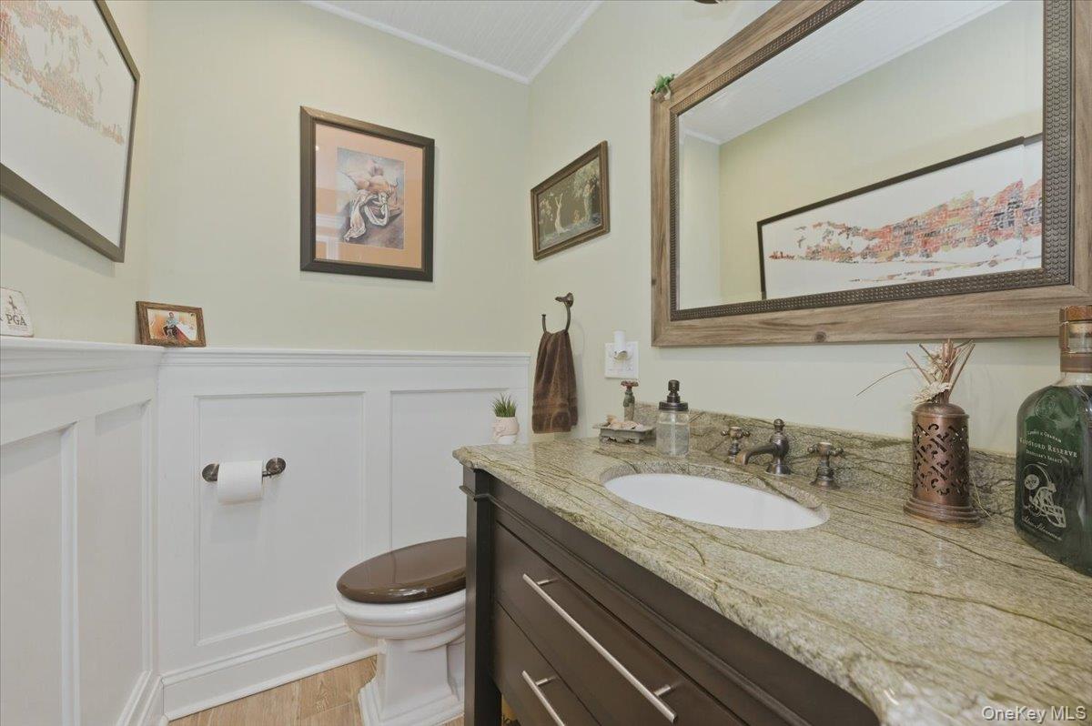 711 Shore Road, Unit 1J Long Beach, NY 11561 - Photo 15 of 22 a bathroom with a granite countertop toilet sink and mirror