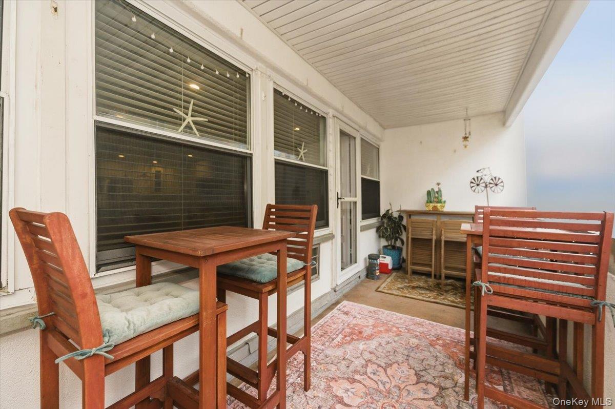 711 Shore Road, Unit 1J Long Beach, NY 11561 - Photo 17 of 22 a backyard of a house with barbeque oven table and chairs