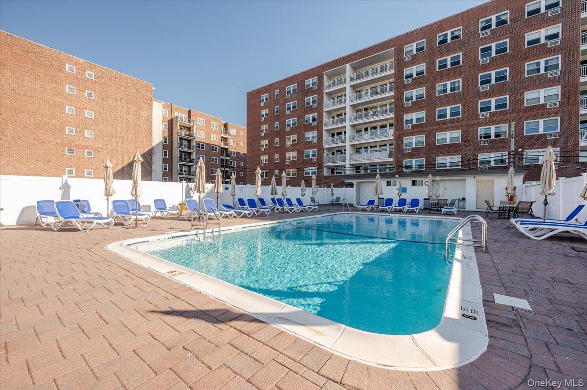 711 Shore Road, Unit 1J Long Beach, NY 11561 - Photo 18 of 22 a view of a swimming pool with a lounge chairs