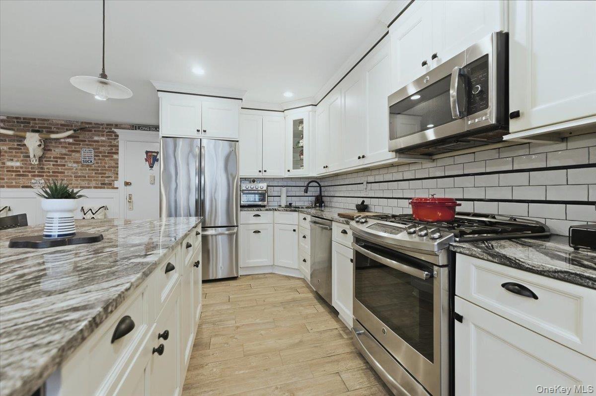711 Shore Road, Unit 1J Long Beach, NY 11561 - Photo 2 of 22 a kitchen with stainless steel appliances granite countertop a stove and a refrigerator