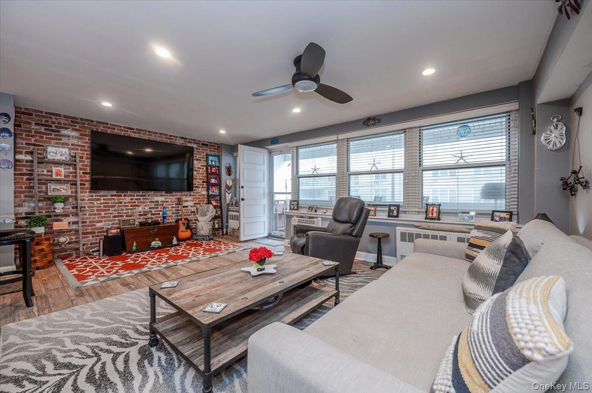 711 Shore Road, Unit 1J Long Beach, NY 11561 - Photo 5 of 22 a living room with fireplace furniture and a flat screen tv