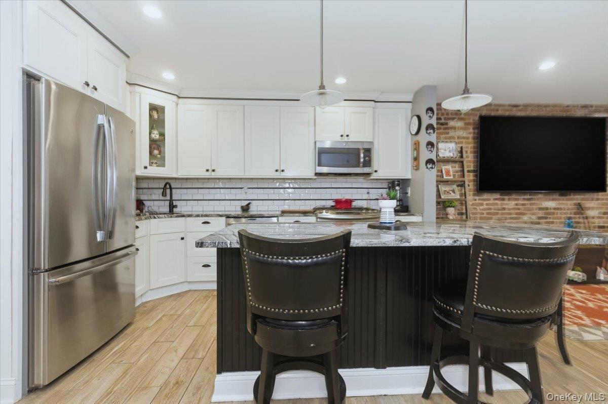 711 Shore Road, Unit 1J Long Beach, NY 11561 - Photo 10 of 22 a kitchen with stainless steel appliances granite countertop a refrigerator a stove a sink and a microwave