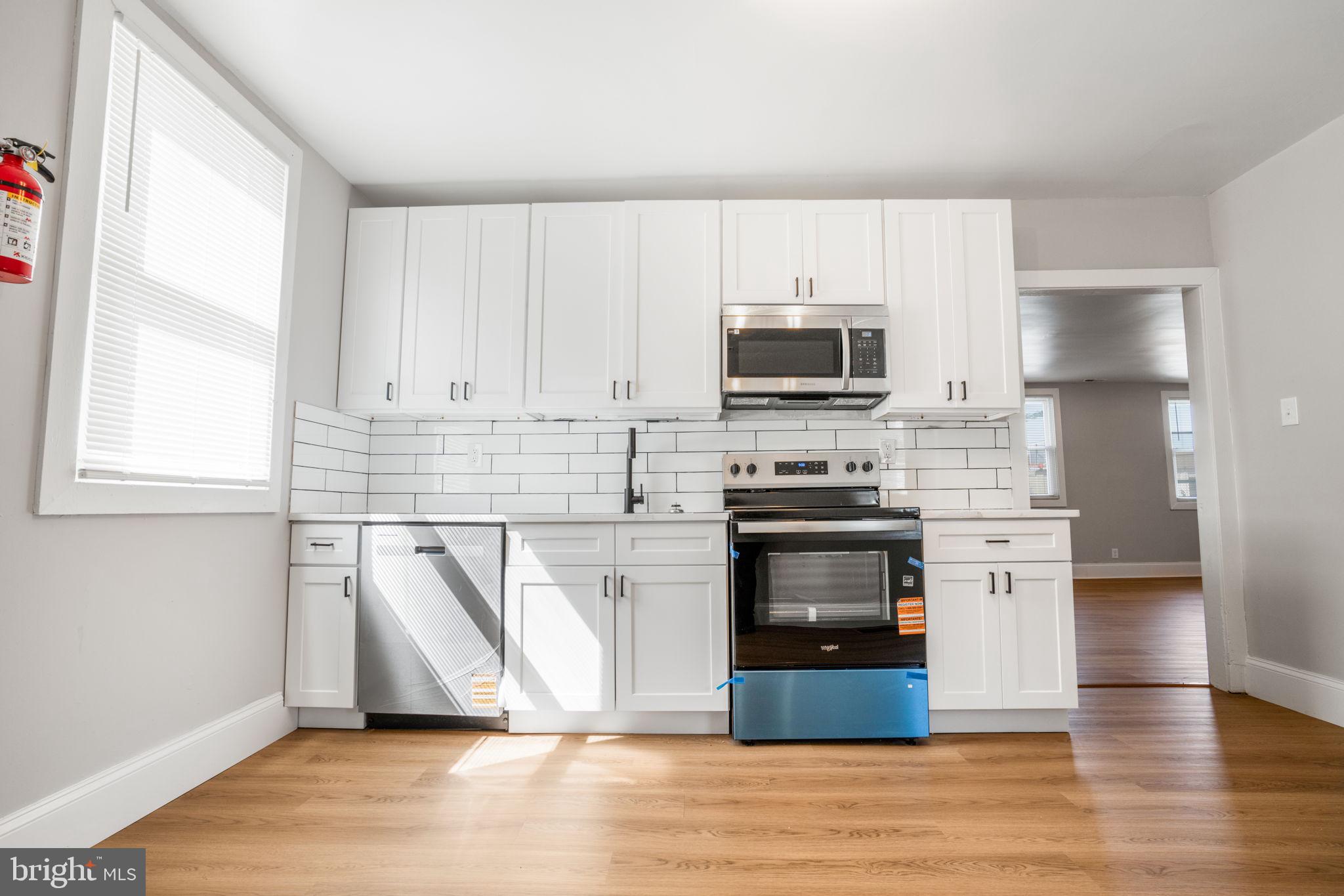 246 Chestnut Street Mount Holly, NJ 08060 - Photo 21 of 25 a kitchen with granite countertop a stove a sink and a microwave