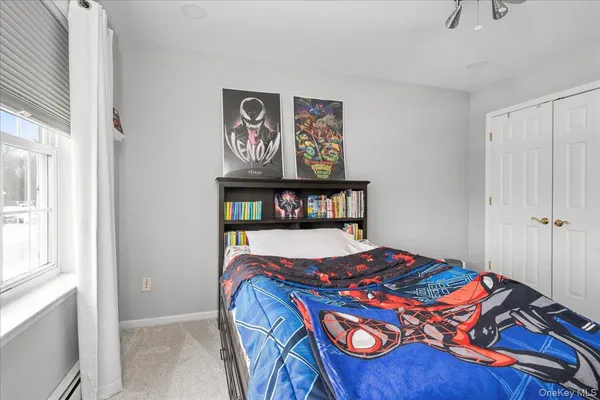 a bedroom with a bed and painting on the wall