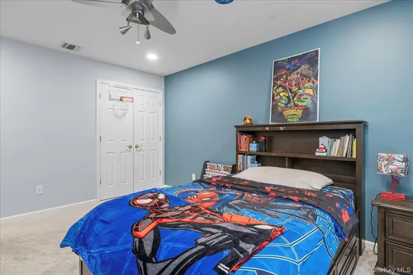 a bedroom with a bed and a painting on the wall