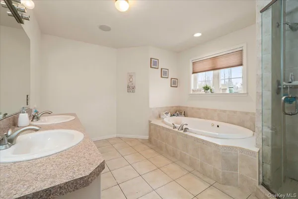 a bathroom with a tub a sink and mirror